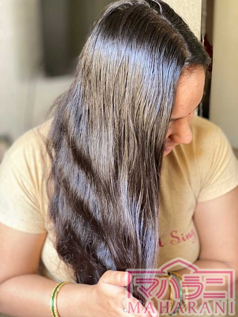 オイルを髪に塗布するインド女性